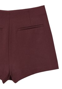 Hochtaillierte bordeauxfarbene Shorts mit zwei horizontalen Gesäßleistentaschen und maßgeschneiderter Naht auf einem weißen Hintergrund.