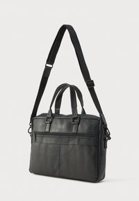 Fekete bőrből készült laptop táska dupla felső fogantyúval, állítható vállpánttal, cipzáras első zsebbel és sima felülettel.