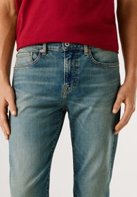 Lyseblå denimjeans med klassisk passform, som har fem lommer, subtil falming, kontrastsøm og metallknapplukking.