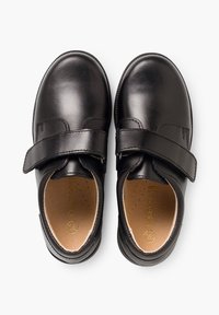 Chaussures en cuir noir avec une finition lisse, bout rond et une large sangle Velcro sur le dessus pour un enfilage facile. Semelles intérieures rembourrées marron incluses.