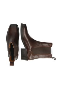 Botas de cuero marrón hasta el tobillo con punta cuadrada, paneles laterales elásticos y un bajo tacón en bloque. Cuenta con una lengüeta en la parte trasera para facilitar su uso.