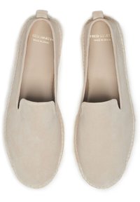 Chaussures à enfiler en daim beige avec un bout rond, peu de coutures et une petite languette au talon. Marquage en relief doré à l'intérieur.
