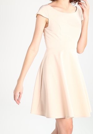 Robe ajustée beige à manches courtes, encolure arrondie et jupe évasée. Fabriquée en tissu lisse avec des coutures discrètes.
