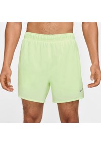 Vaaleanvihreät urheilushortsit, jotka on valmistettu sileästä ja kevyestä materiaalista. Ominaisuuksina joustava vyötärö ja pieni harmaa Nike-logo vasemmalla puolella.
