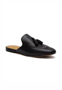 Scarpa slip-on in pelle nera con punta appuntita, dettagli decorativi con frange e cuciture sottili. Texture liscia con suola piatta.