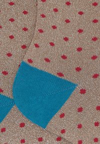 Calze marroni con pois rossi e sezione del tallone turchese. Il materiale presenta una leggera lucentezza, creando un aspetto strutturato.