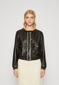 Giubbotto bomber in ecopelle nera con polsini elasticizzati, due tasche frontali e una cerniera bianca. Presenta un collo rotondo e un design cropped.