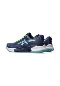 Zapatillas deportivas marinas con cordones verdes, que cuentan con una parte superior de malla texturizada, una media suela blanca y una suela exterior de goma flexible con un patrón de relieve único.