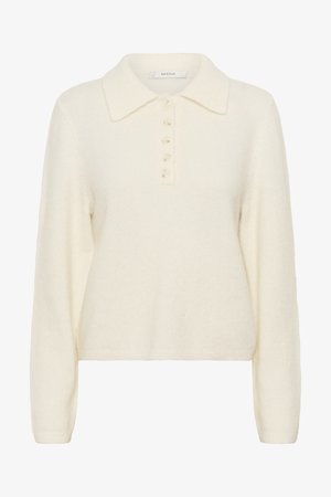 Kreminės spalvos, minkšto trikotažo megztinis su apykakle ir penkių sagų užsegimu. Turi ilgomis rankovėmis ir dėžutės formos siluetą.