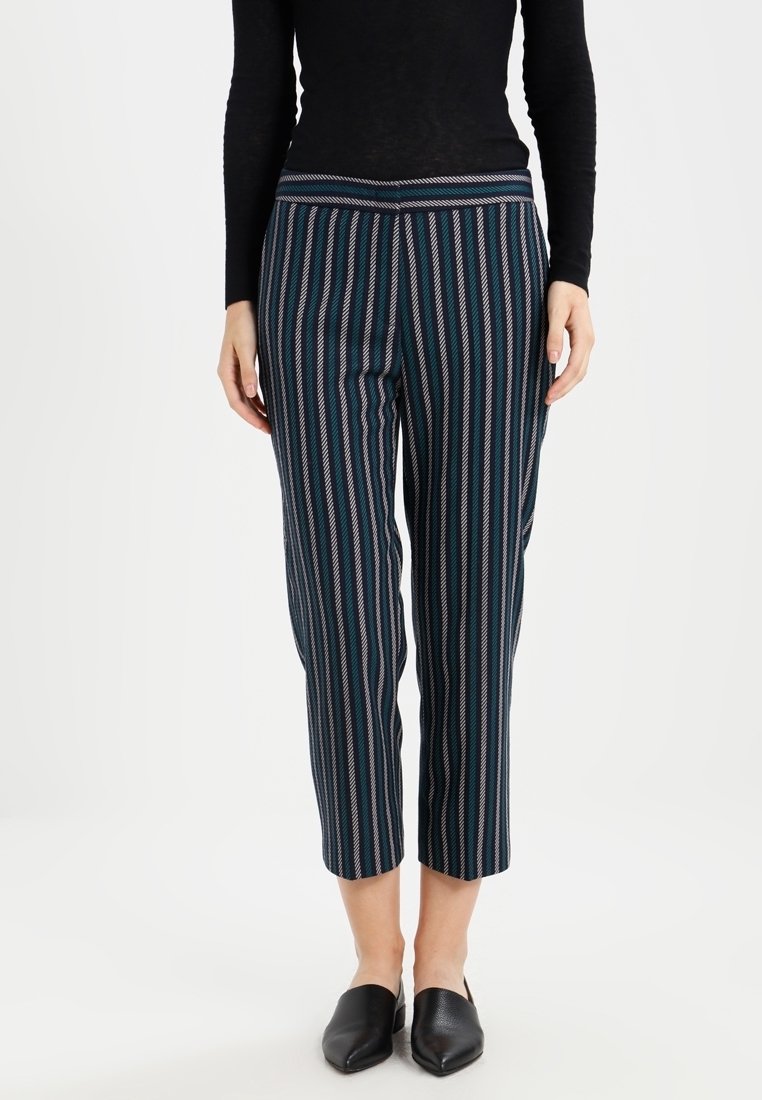 Randiga byxor i marinblått, med vertikala linjer i teal och rosa. Tyget är slätt; kort längd med åtsittande midja.