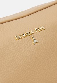 Borsa in pelle beige chiaro con il nome del marchio in oro embossato "PATRIIZIA PEPE" e un piccolo dettaglio in argento. Texture liscia con una leggera trama.