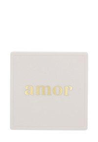 Kvadratisk, texturerad keramikplatta i mjuk rosa med en slät yta. Har "amor" i metallisk guldtext i mitten.