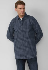 Marineblauw geruite shirt van geweven stof, met een knoopsluiting aan de voorkant, een klassieke kraag en lange mouwen. Inclusief een borstzak.