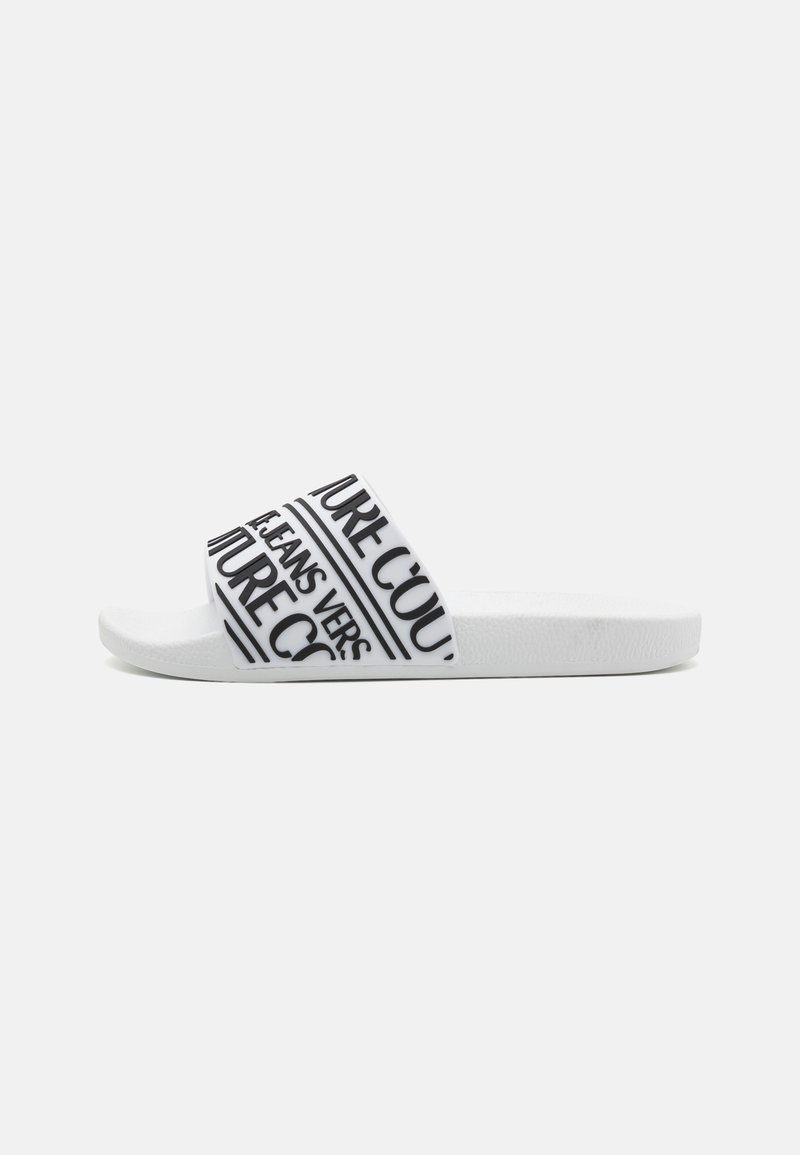 White slide sandal with a wide strap featuring black text patterns. Text includes "FUTURE" and "JEANS." Textured sole for grip.
