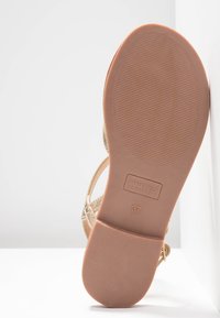 Sole in sandal color tan con gomma testurizzata, etichettato "ANNA FIELD," taglia 37. Presenta cinturini stretti e una finitura liscia.