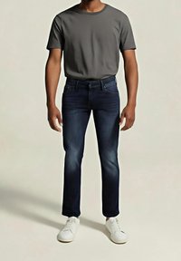 Camiseta gris de cuello redondo combinada con vaqueros azul oscuro de corte ajustado y zapatillas blancas. El conjunto presenta un diseño sencillo y casual sin estampados.