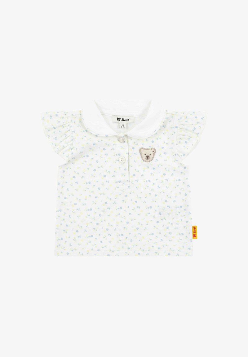 Bílý bavlněný tričko s krátkými volánkovými rukávy, květinovým vzorem a aplikací medvěda na hrudi. Obsahuje límec a zapínání na knoflíky.