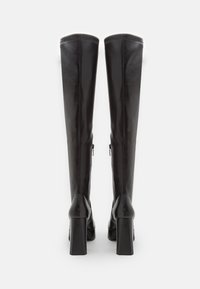 Knee-high black leather boots with a smooth texture, square high heel, and visible zippers on the outer sides. Simple design, no patterns.
