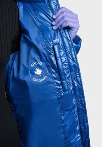 Blå isolerad jacka med blank finish, utrustad med en vit logotyp och quiltad struktur. Innehåller sidofickor och huva.