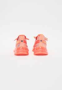 Scarpe sportive rosa e corallo con tomaia in rete intrecciata, dettagli testurizzati e una suola in gomma spessa. Presentano lacci e un marchio sul tallone.