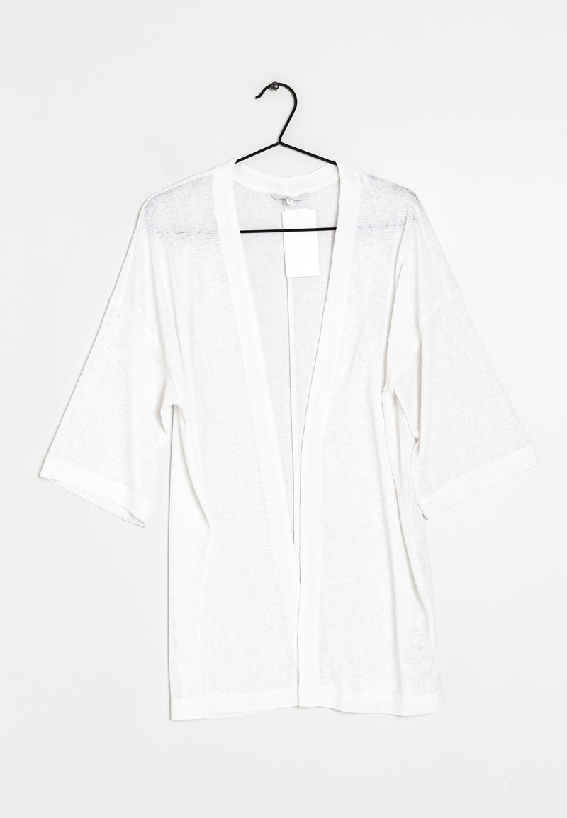 Weißer, leichter Kimono-Cardigan mit kurzen Ärmeln, offenem Vorderteil und dezenter Textur. Hängt an einem schwarzen Haken. Etikett angebracht.