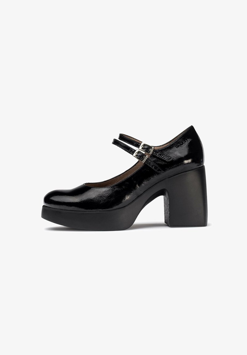 Zapato Mary Jane de charol negro con punta redondeada, tacón grueso de bloque y dobles correas ajustables con una hebilla metálica.