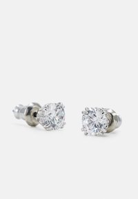 Paire de boucles d’oreilles en argent avec des pierres précieuses rondes et claires montées sur des griffes à six branches sur fond blanc.