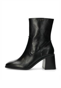 Černá kožená kotníková bota s elegantním designem, špičatou špičkou a silným blokovým podpatkem. Obsahuje zakřivené otvorení a minimální detaily šití.