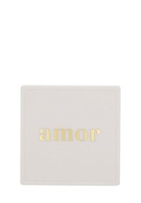 Vitt rektangulärt föremål med ordet "amor" präglat i gyllene bokstäver centrerat på ytan.