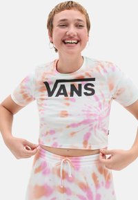 Skåret tie-dye t-shirt i pastelfarver med sort "VANS" logo. Korte ærmer, blødt bomuldsstof og legende swirl mønster.
