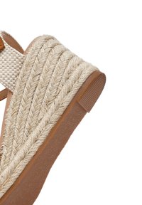 Sandalia cuña con parte superior de yute trenzado, color beige, suela de goma con patrón texturizado y tira de acento en color marrón.