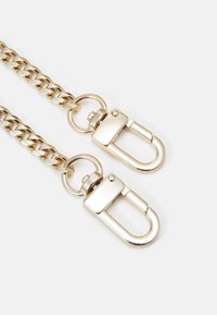 Dvě zlaté řetězy s obdélníkovými otočnými karabinami na bílém pozadí.