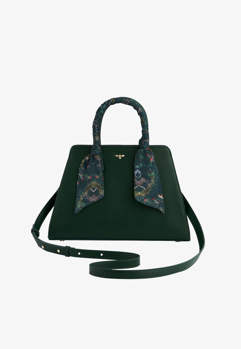 Zelená kožená kabelka so štruktúrovaným tvarom, obsahujúca vzorovaný hodvábny šál zauzlený na rukoväti a odnímateľný popruh na rameno.