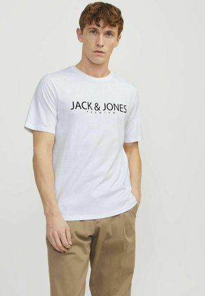 T-shirt en coton blanc à manches courtes, arborant un logo noir "JACK & JONES PREMIUM" sur la poitrine. Coupe décontractée avec un col rond.