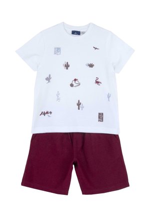 Maglietta bianca in cotone con stampe colorate di animali e cactus; abbinata a pantaloncini color bordeaux con tasche laterali e vestibilità ampia.