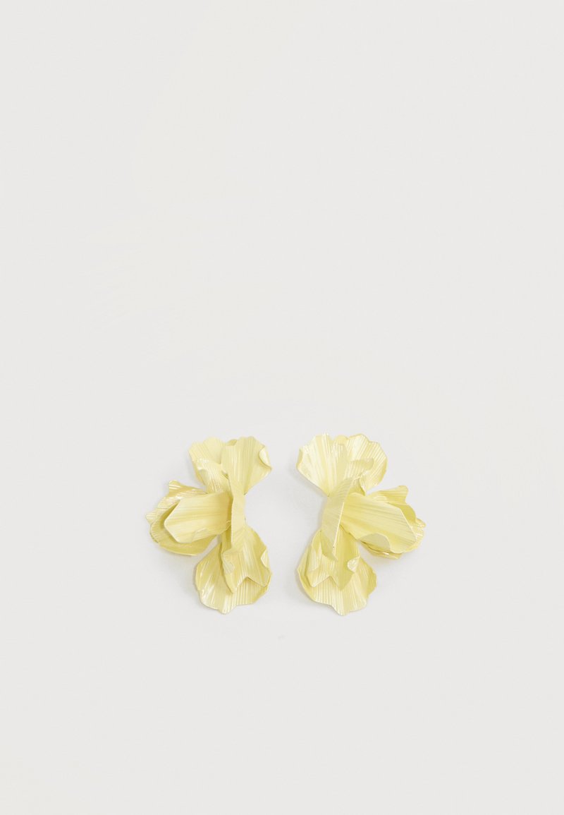 Par øredobber formet som blomster i lys gul med lagdelte, teksturerte kronblader mot en lys bakgrunn.