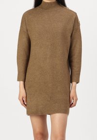 Abito in maglia marrone con collo alto, maniche a tre quarti, polsini a coste e bottoni sulle spalle. Tessuto morbido e vestibilità comoda.