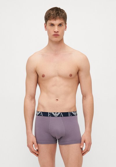 Sivé boxerky s námorníckym pásom, ktorý má biele logo. Hladký material s priliehavým strihom a dĺžkou do polovice stehna.