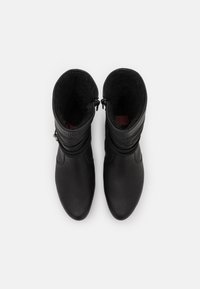 Botas de cuero negro con un acabado suave, cierres de cremallera y forro de forro polar en el interior para mayor calidez y comodidad.