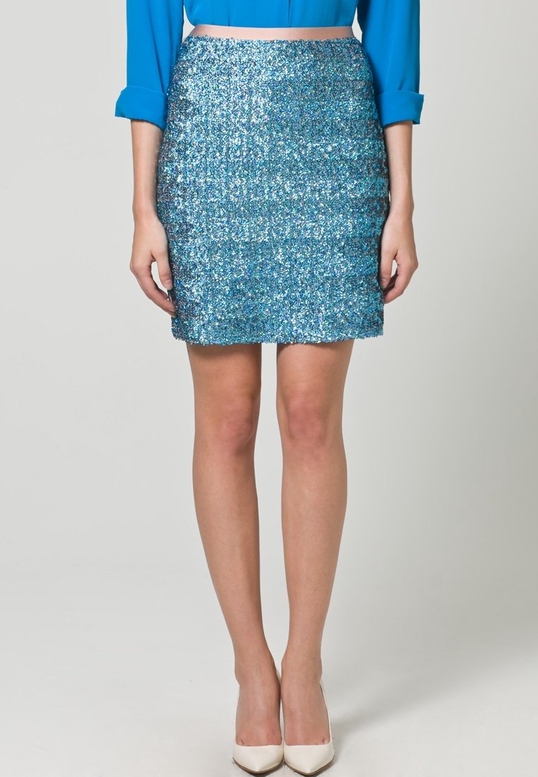 Blå paillettmini kjol med en figurnära form, mjuk textur och lagerdesign. Kombinerat med krämfärgade klackskor med spetsig tå.