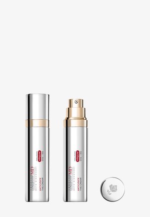 Zwei silberne und goldene Pumpspender mit Anti-Aging-Creme, beschriftet mit "Anticipate The Cream", wobei eine Kappe abgenommen und daneben gelegt wurde.