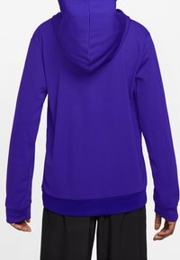 Sudadera con capucha de color púrpura, con una textura suave, mangas largas y un corte relajado. Presenta un bolsillo tipo canguro y puños y dobladillo acanalados.