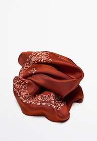 Foulard en soie de couleur rouille avec des motifs de paisley et de fleurs blancs, présentant une texture douce et un design légèrement froissé.