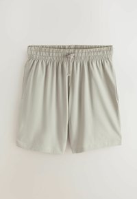 Shorts décontractés gris clair avec taille élastique et cordon de serrage à l'avant, dotés de poches latérales, posés à plat sur un fond blanc.