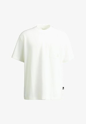 Balta īsroku teksturēta T-krekls ar mazu krūšu kabatu un melnu etiķeti uz apakšējā sānu šuves.