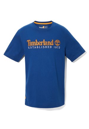 T-shirt Timberland bleu manches courtes avec logo orange et texte « Established 1973 » centré sur la poitrine.