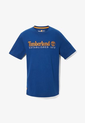 Camiseta de manga corta Timberland azul con logo naranja y texto "Established 1973" centrado en el pecho.
