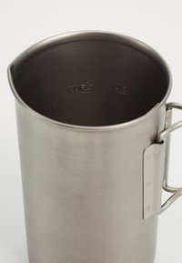 Tasse à mesurer en acier inoxydable avec un manche, comportant des mesures gravées pour les tasses et les onces à l'intérieur, et un extérieur lisse et mat.