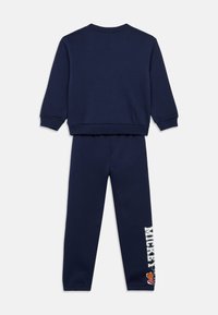 Granatowy dres z bluzą i spodniami. Miękka tkanina, okrągły dekolt, ściągacze przy mankietach, spodnie z napisem "MICKEY" i graficznymi detalami na nogawce.
