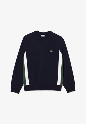 Marinblå sweatshirt med raglanärmar, vita och gröna randiga detaljer på sidorna, samt en liten grön logotyp på bröstet.
